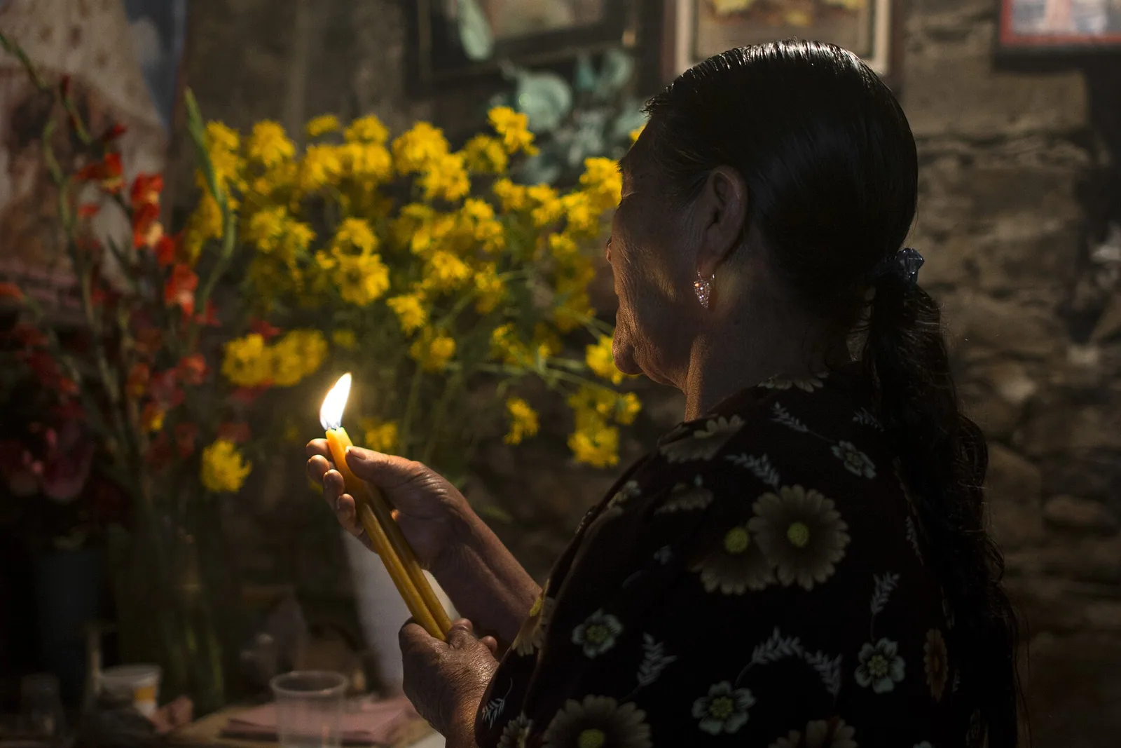 Huautla de Jiménez, in the Sierra Mazateca. A curandera prepares a limpia, a cleansing — not a mushroom velada, but the same practitioner, the same room and the same repertoire of candle, smoke and spoken address that a velada is held in.