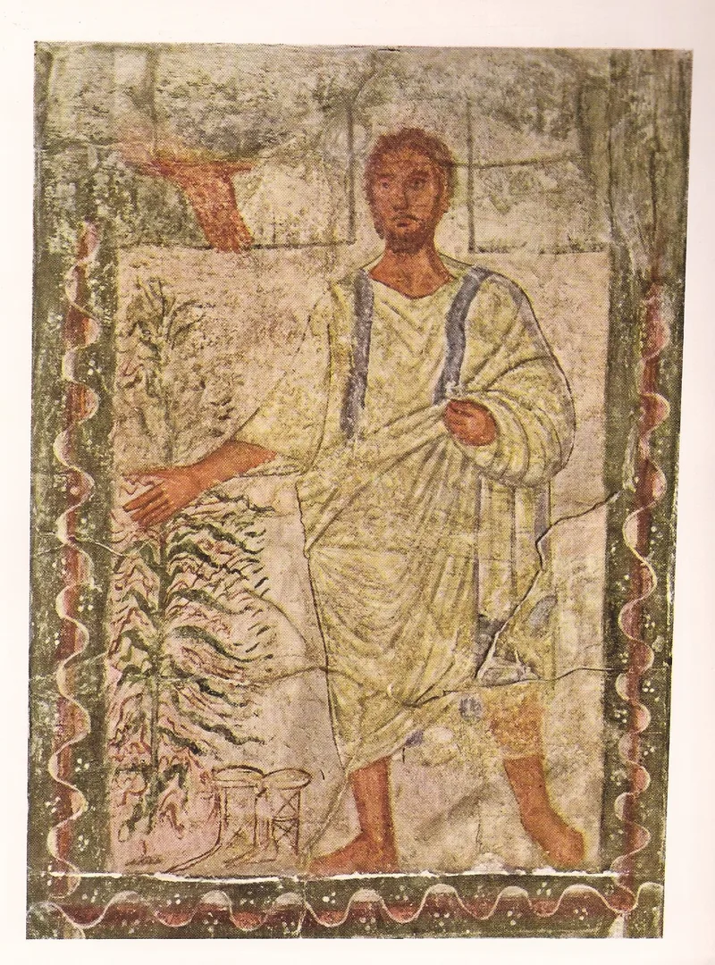 Wall painting: a bearded man in a pale robe stands barefoot beside a leafy bush, while a hand reaches down from the upper left; a painted border frames the panel