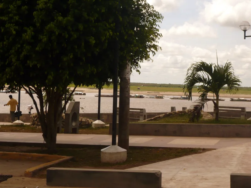 The Ucayali river at Pucallpa seen from the Malecón Grau, with moored riverboats, sandbanks exposed by low water and a far bank of forest.