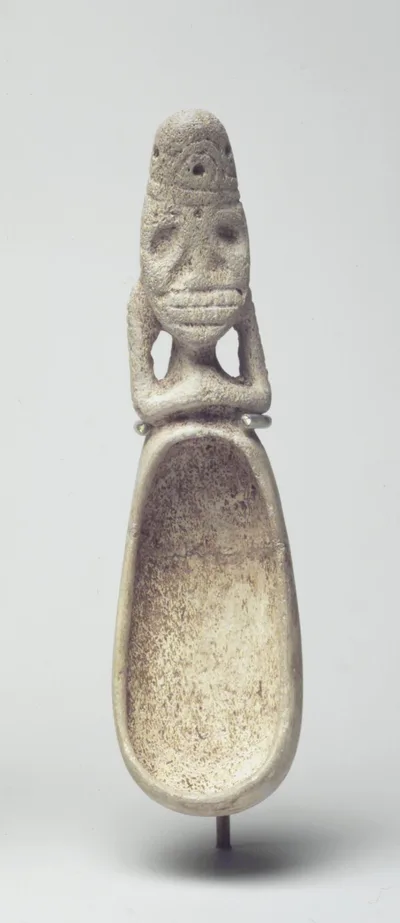 Bone spoon with a deep bowl, its handle carved as a crouching figure